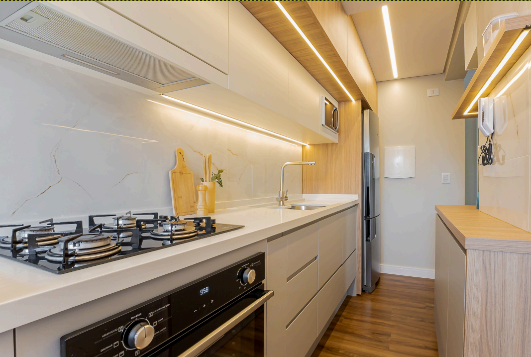 Cozinha Integrada — Iluminação linear embutida, bancada contínua e armazenamento pensado ao centímetro.